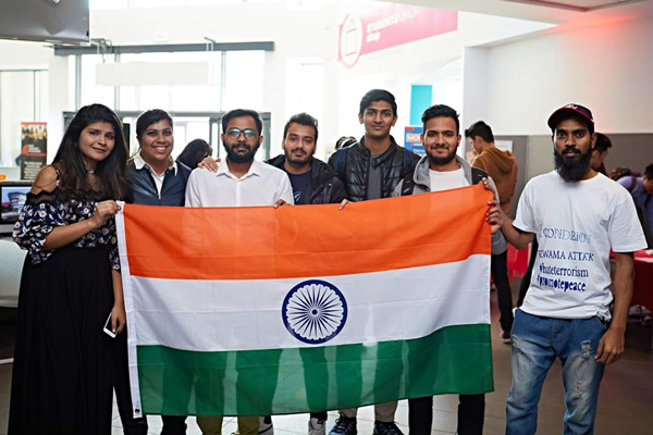 A group photo of students from the University Indian society holding up an Indian flag.