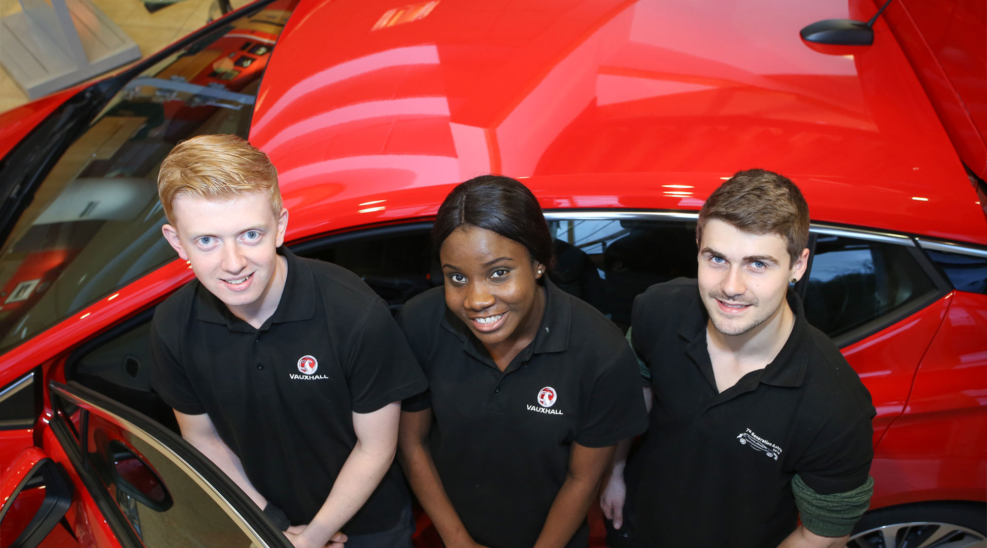 Students on placement at Vauxhall in front of a bright red Vauxhall.From left to right Luke Rowley, Abiobelari Collins, Jack and James Lindsay.