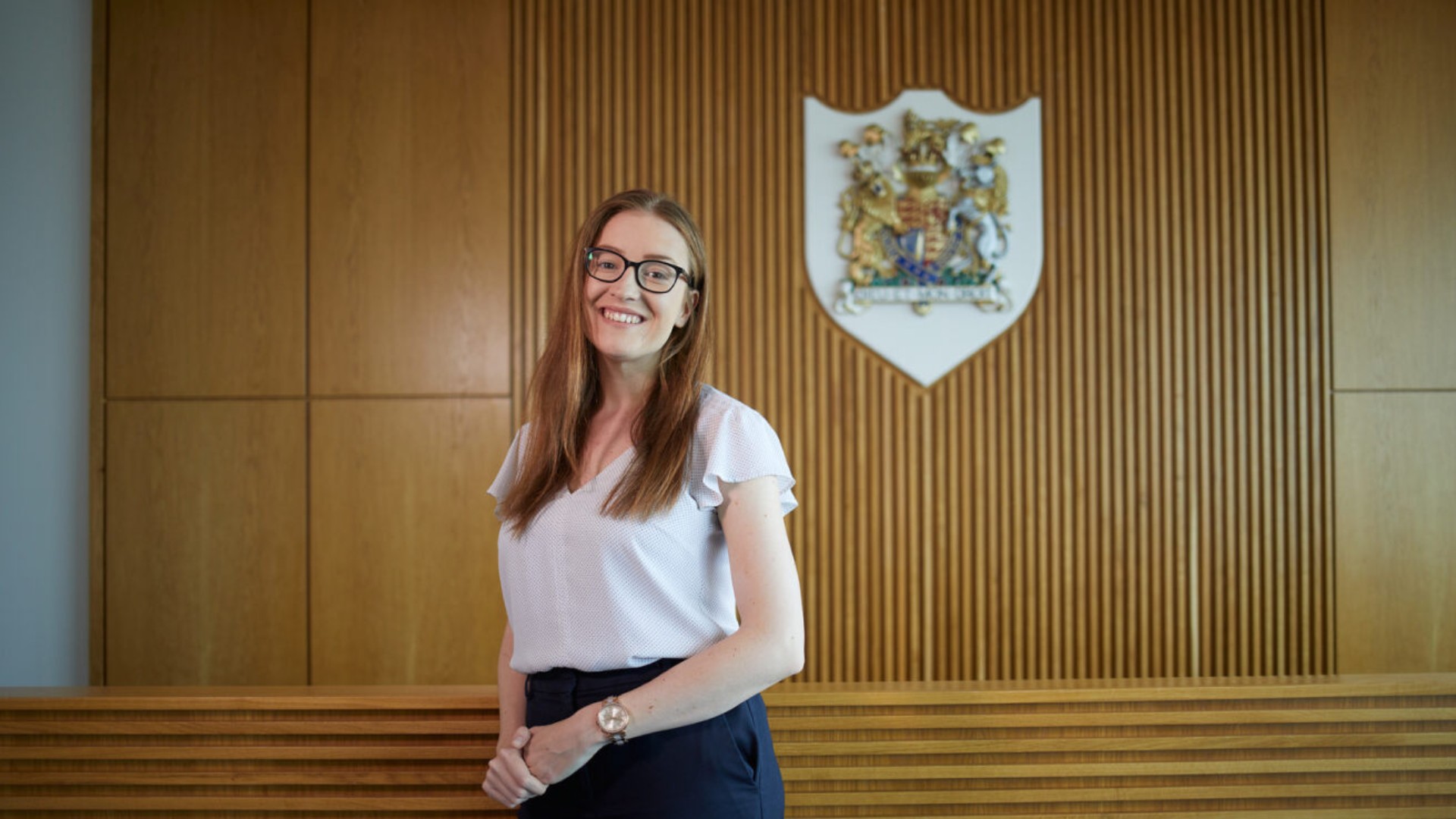 Ellie Hirst smiling in the mock courtroom as Huddersfield Law School