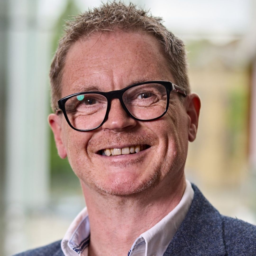 Headshot of Julian White. Smiling facing camera