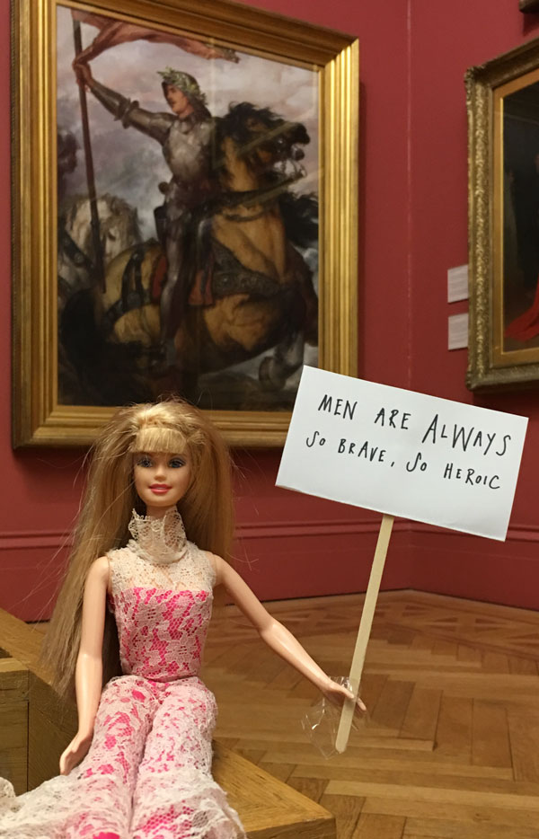 Art Activist Barbie protesting that men are always portrayed as brave and heroic
