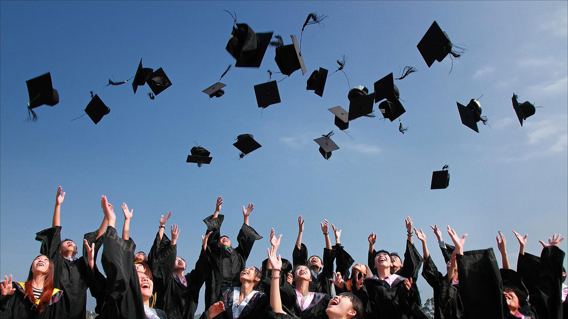 Students throwing graduation hats in the air