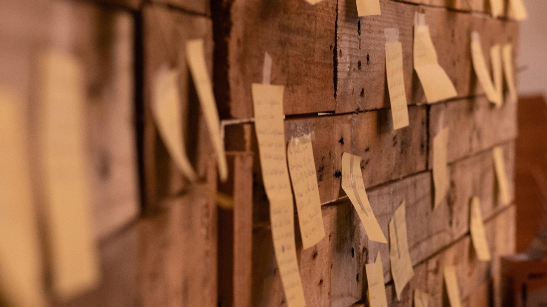 Wooden noticeboard with variety of post-it notes