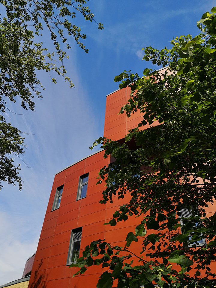 Huddersfield Business School at the University of Huddersfield framed by leafy trees