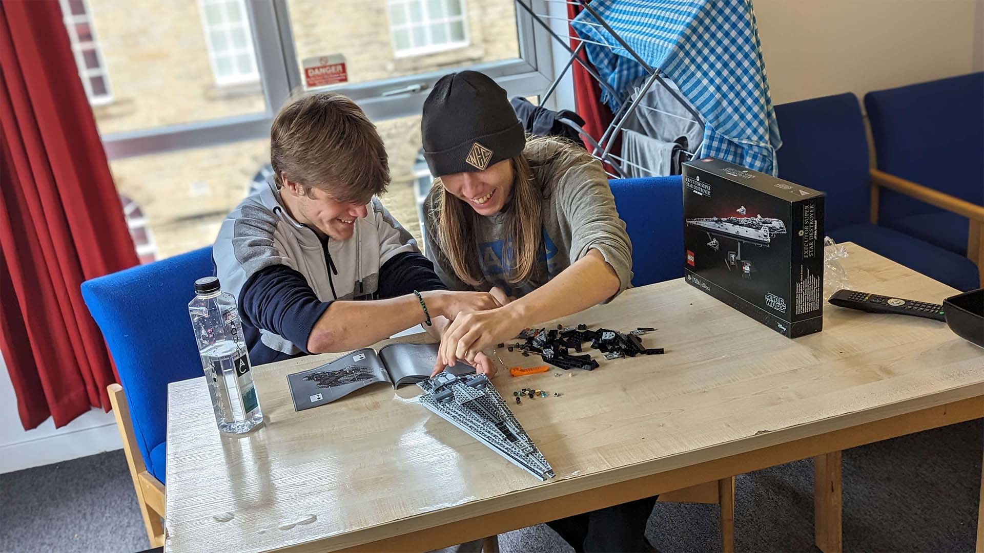 Two students completing a Star Wars Executor Super Star Destroyer lego set.