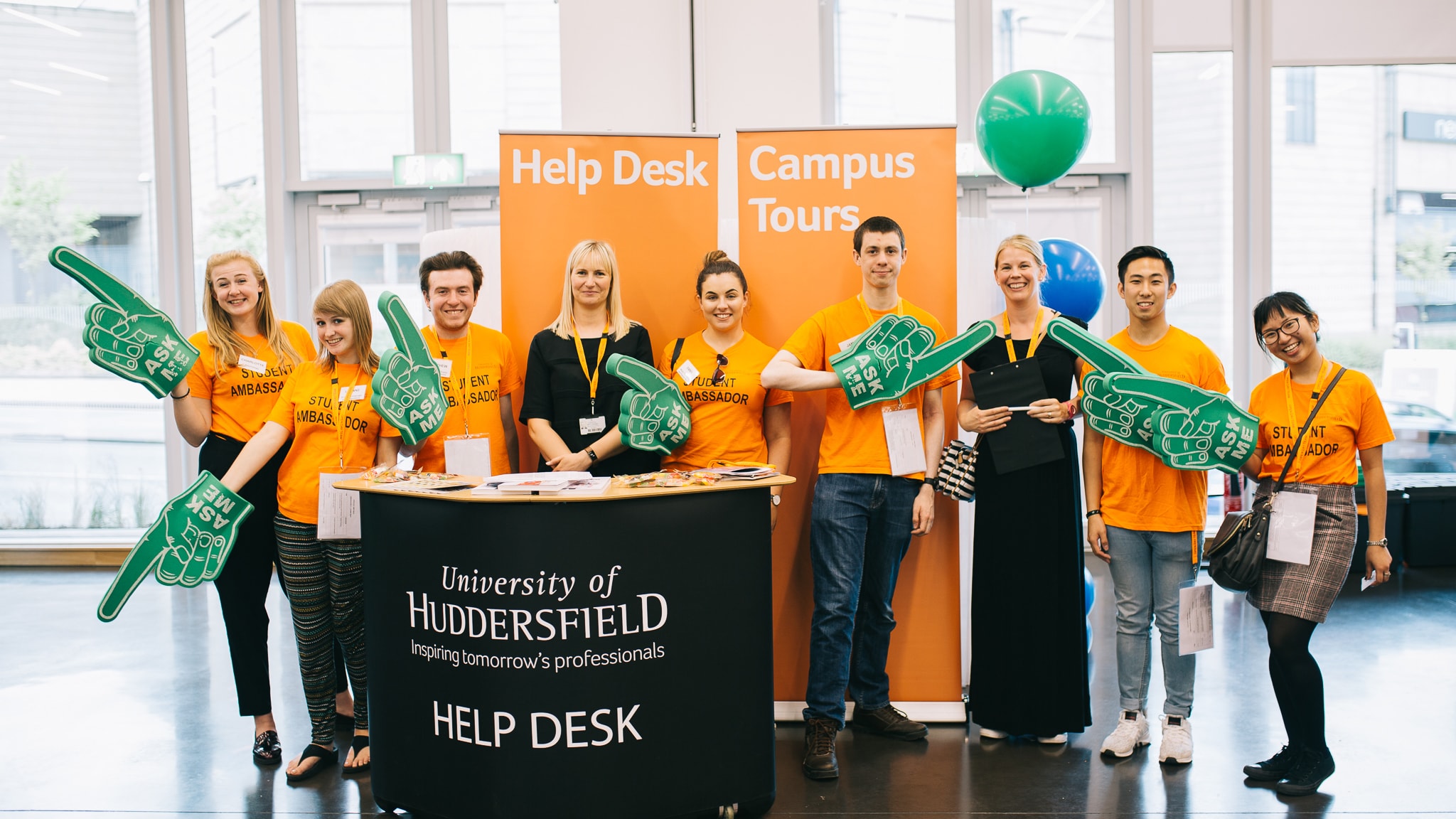 This is the open day helpdesk with orange shirts on with a small podium