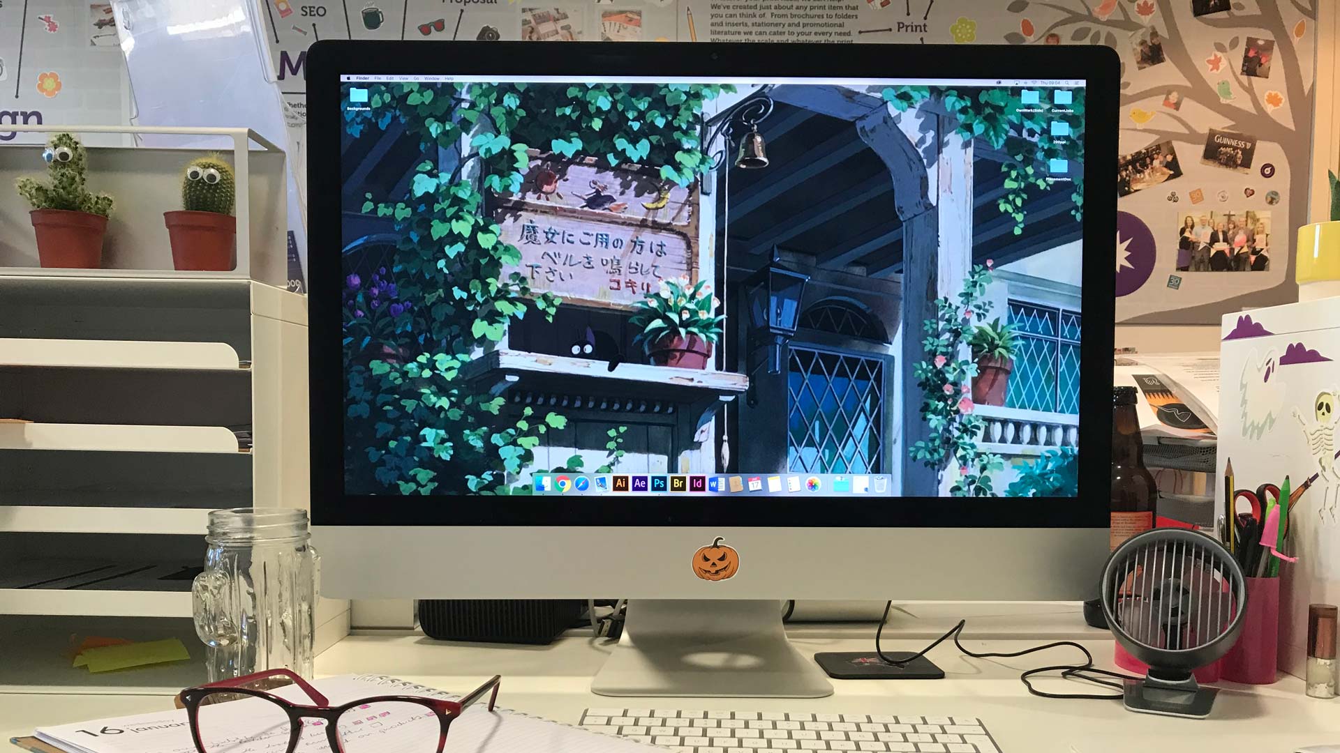 Sarah Richard's desk with an iMac, notes and pair of glasses.