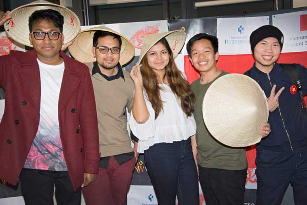 five students posing with chinese coolie hats.