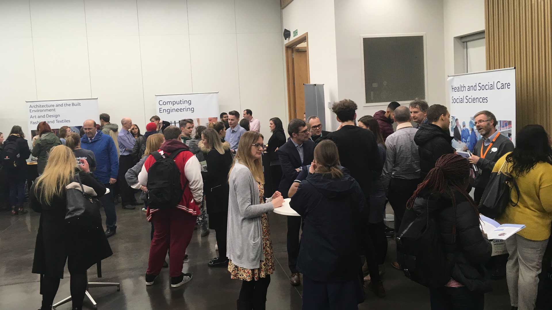 A picture of a hall where a postgraduate fair is taking place.