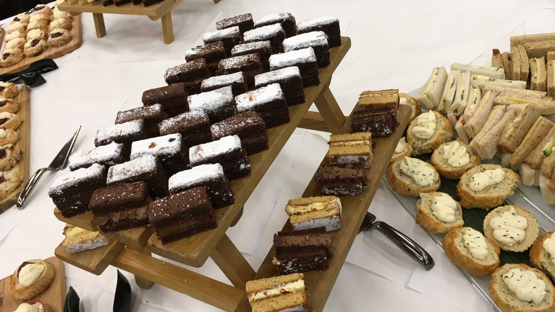 An image is an assortment of cakes and sandwiches