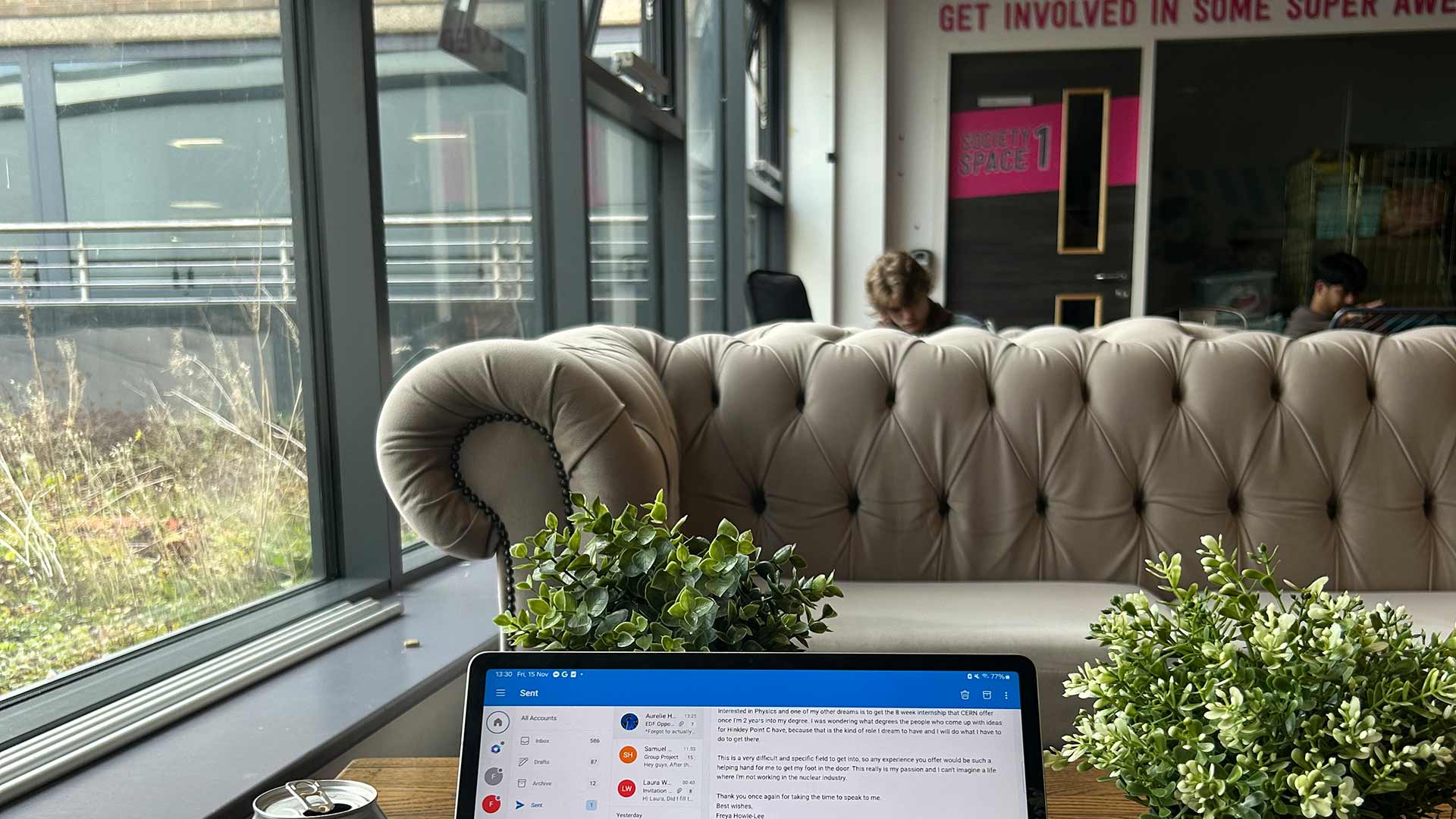 Freya's laptop on a table opposite a sofa in Student Central.