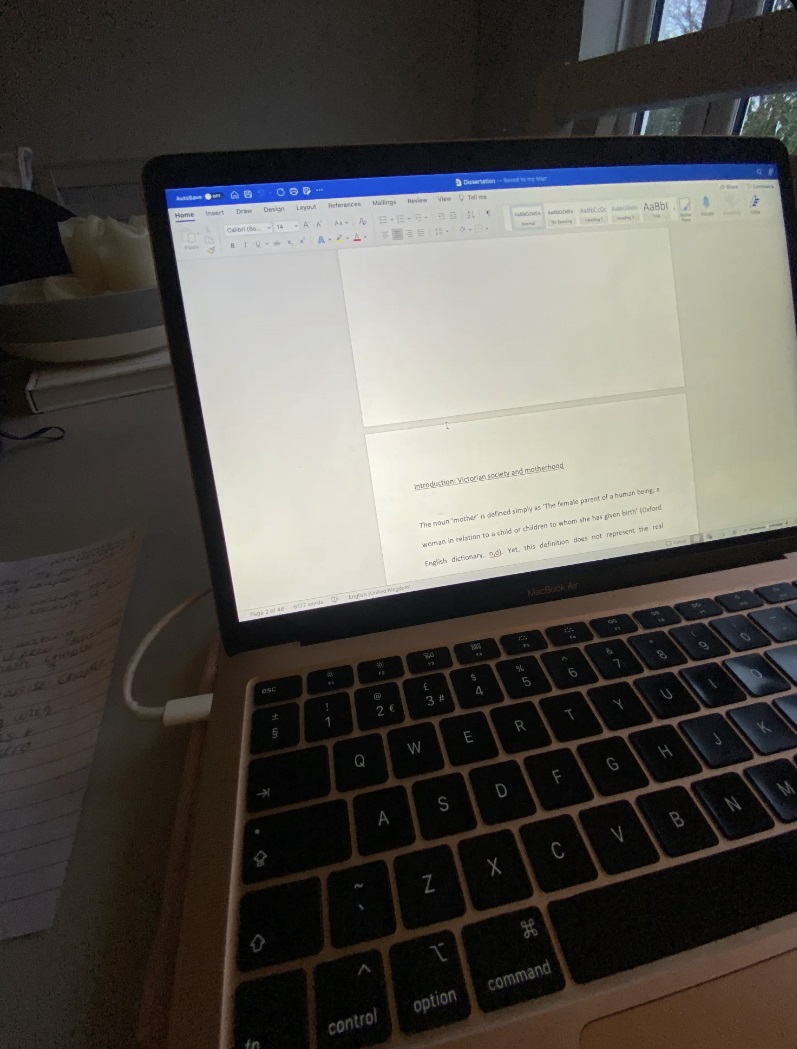 A classroom with a laptop screen and keyboard in the foreground