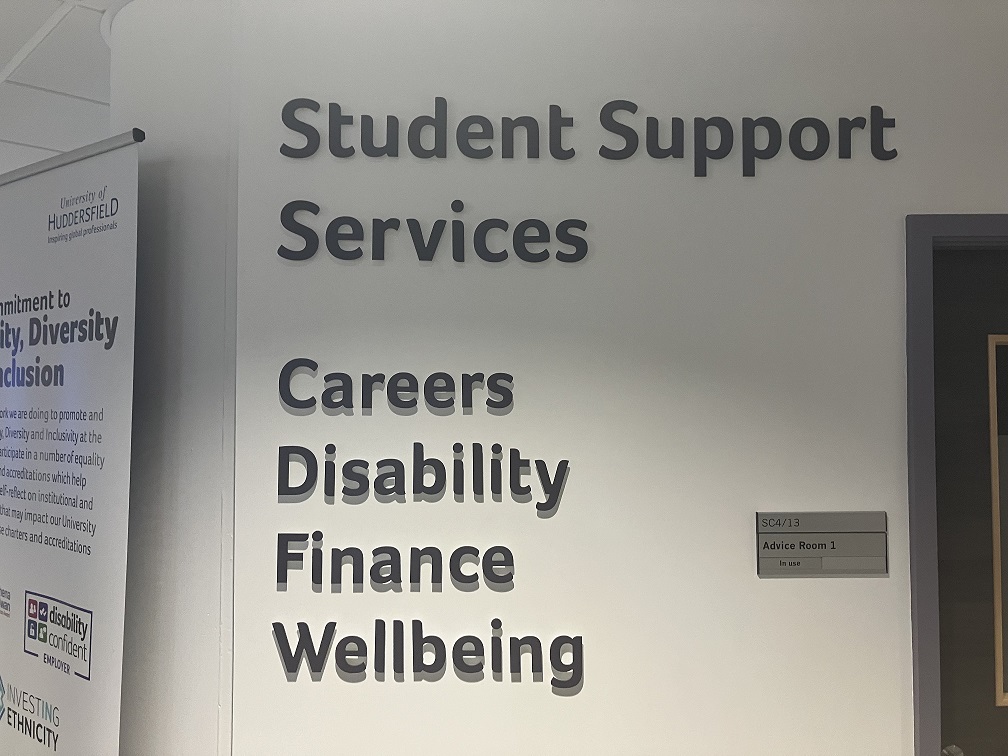 A white wall with black writing which says student support services, careers, disability, finance, wellbeing