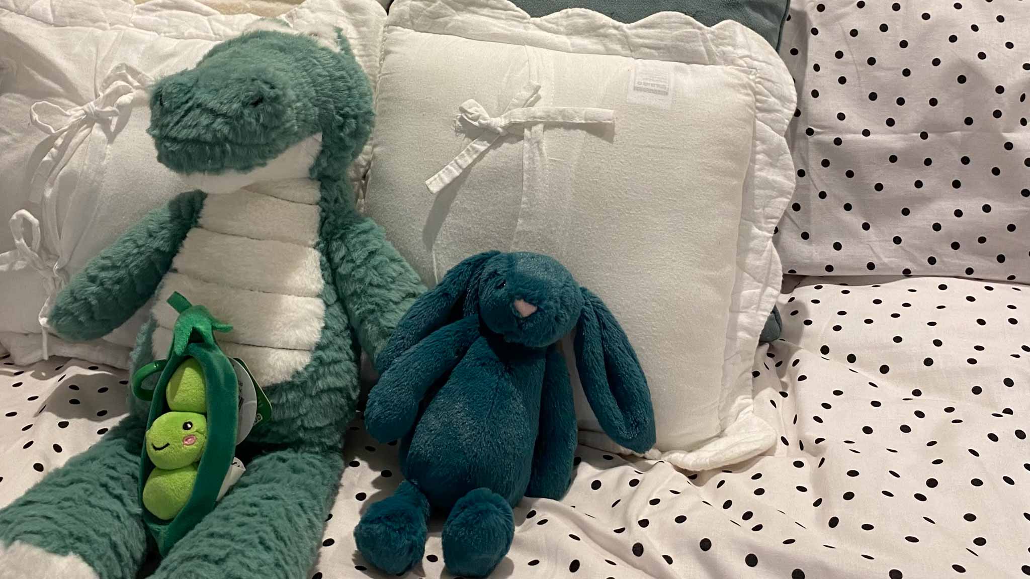Two soft toys on a bed