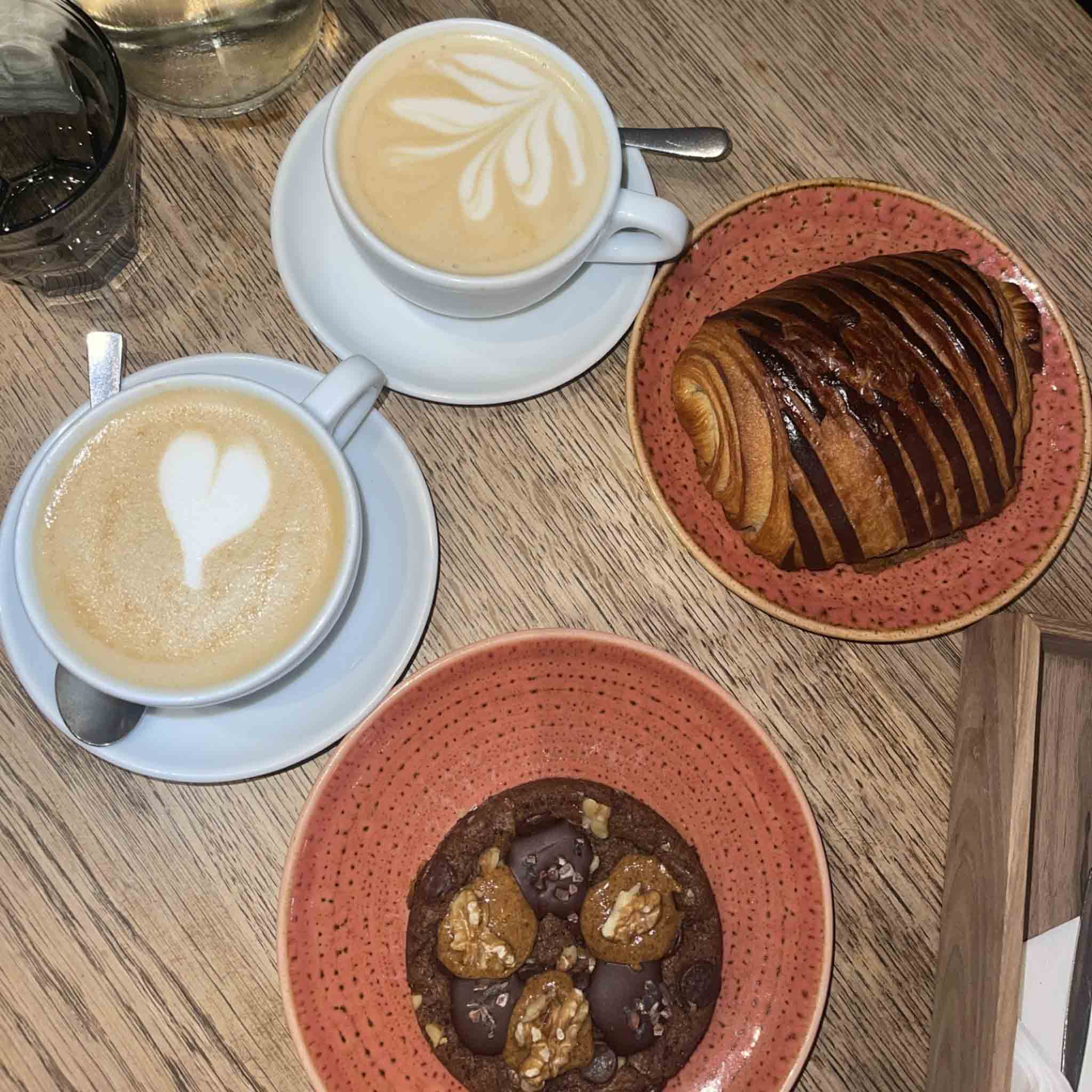 Two cups of coffees and pastries