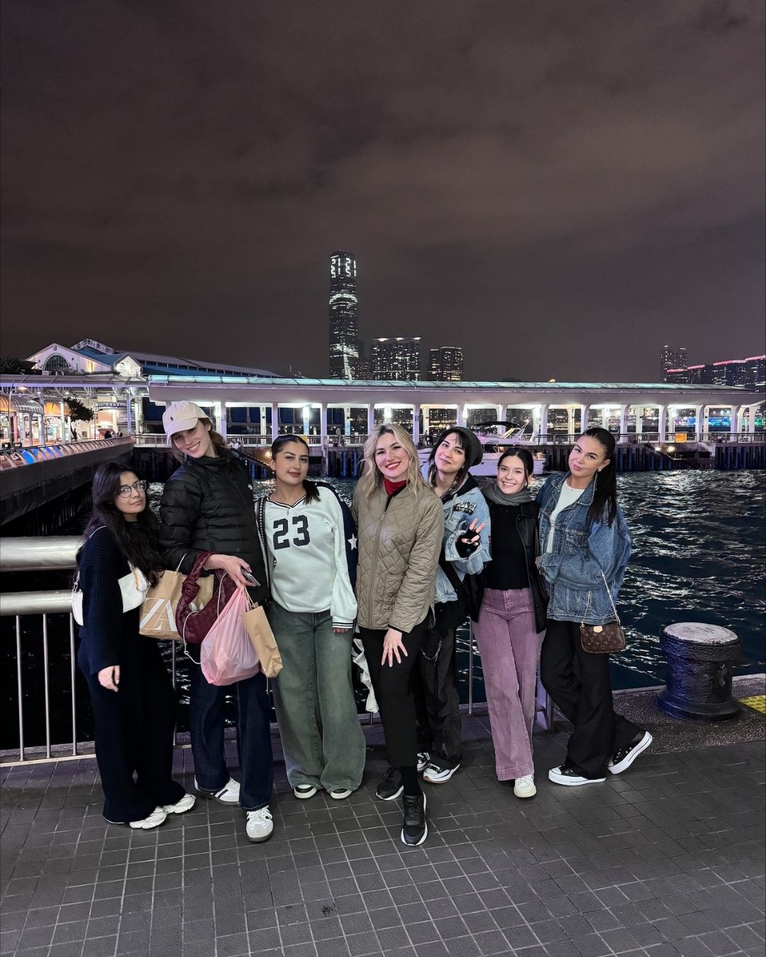 A group of smiling students in front of a city backfrop at night