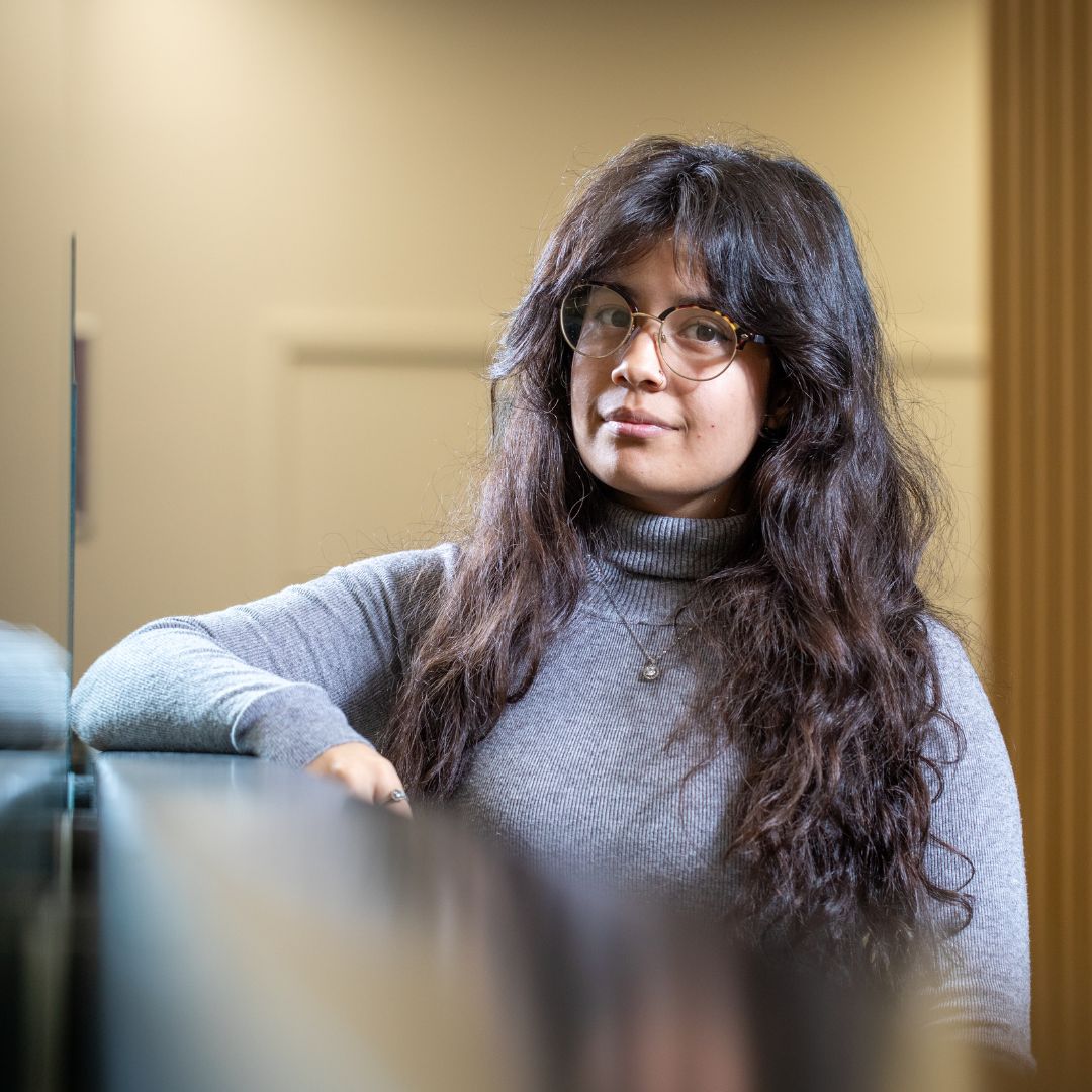 A student smiling leaning on a railing