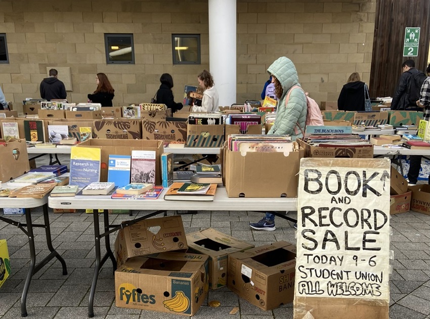 Students browse an outdoor pop-up shop selling books and records