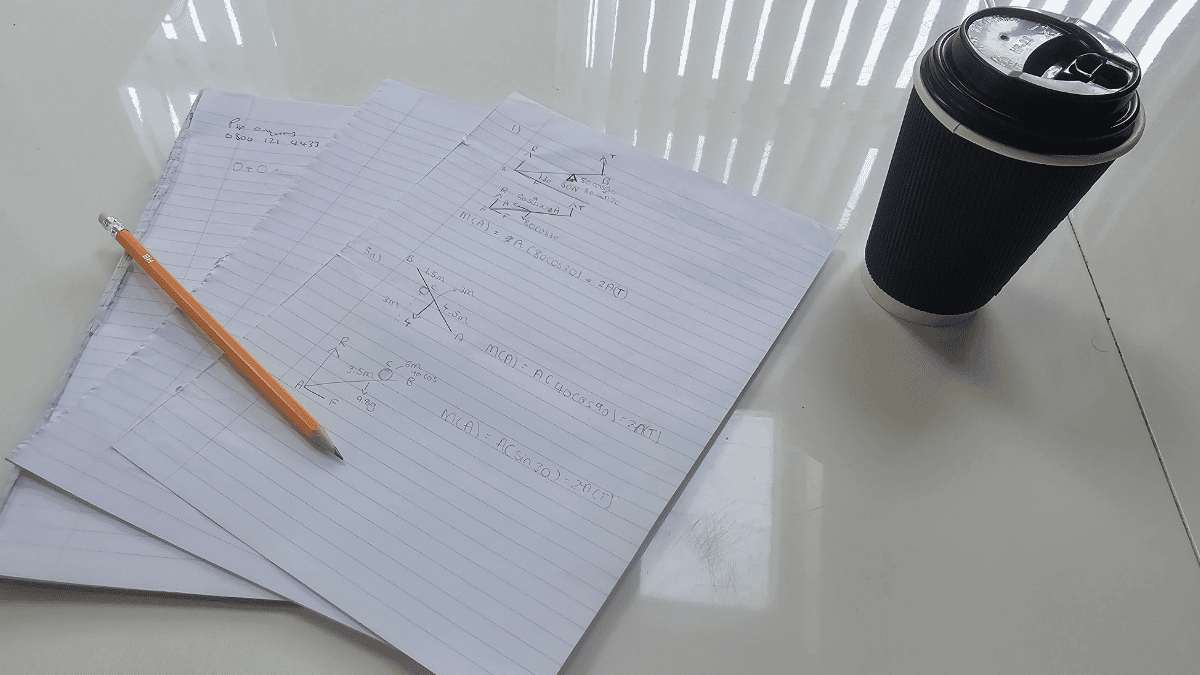 Papers, a pencil and coffee on a desk