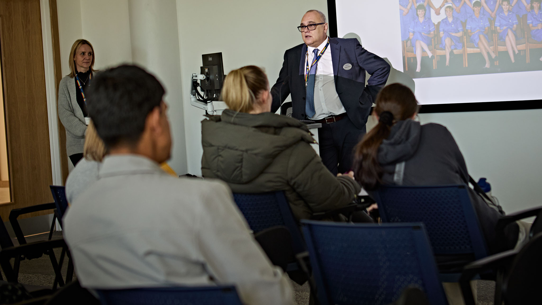 An academic addresses a room full of people