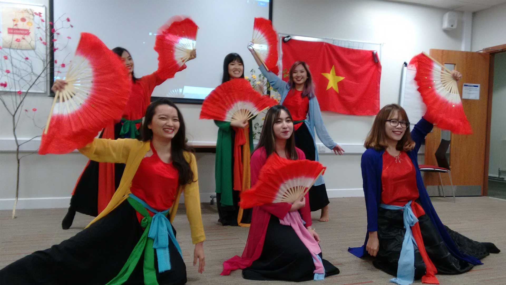 Vietnamese students celebrate Lunar New Year with fans and flags.