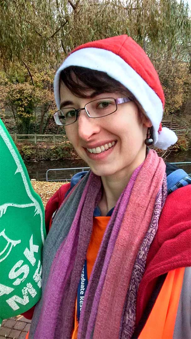 Elizabeth working an Open Day as a Student Ambassador with large foam hand and santa hat