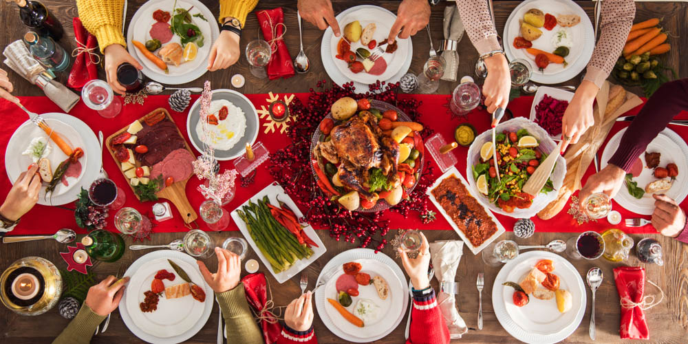 People sat round a table eating Christmas dinner