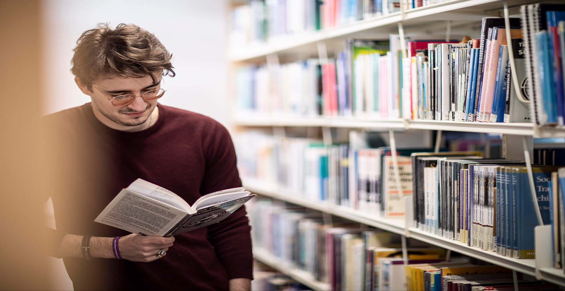 Tom reading a book in the library