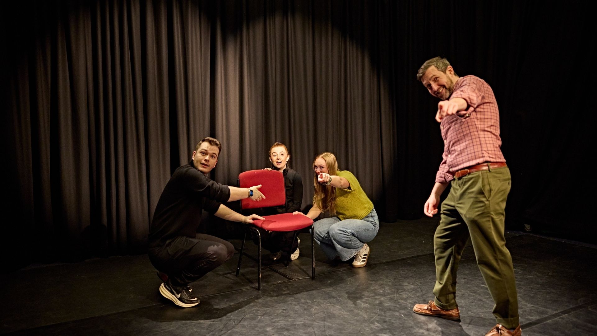 Drama teacher and students looking an posing to camera