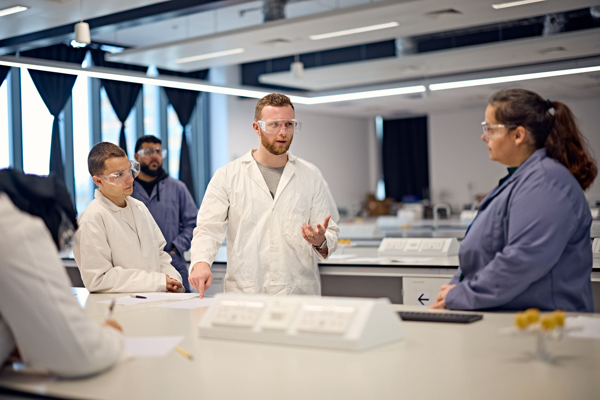 Students in white lab coat in lab