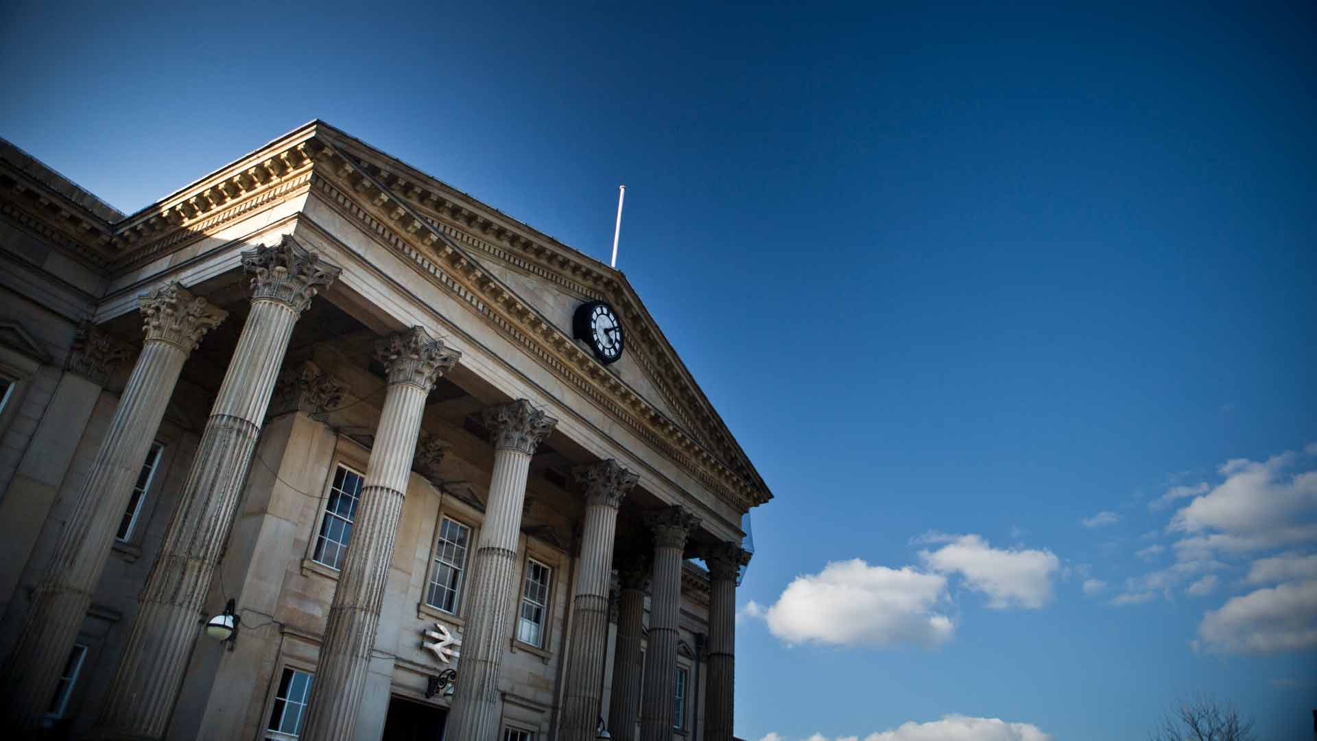 Huddersfield Train Station building on a summers day with clear blue skies