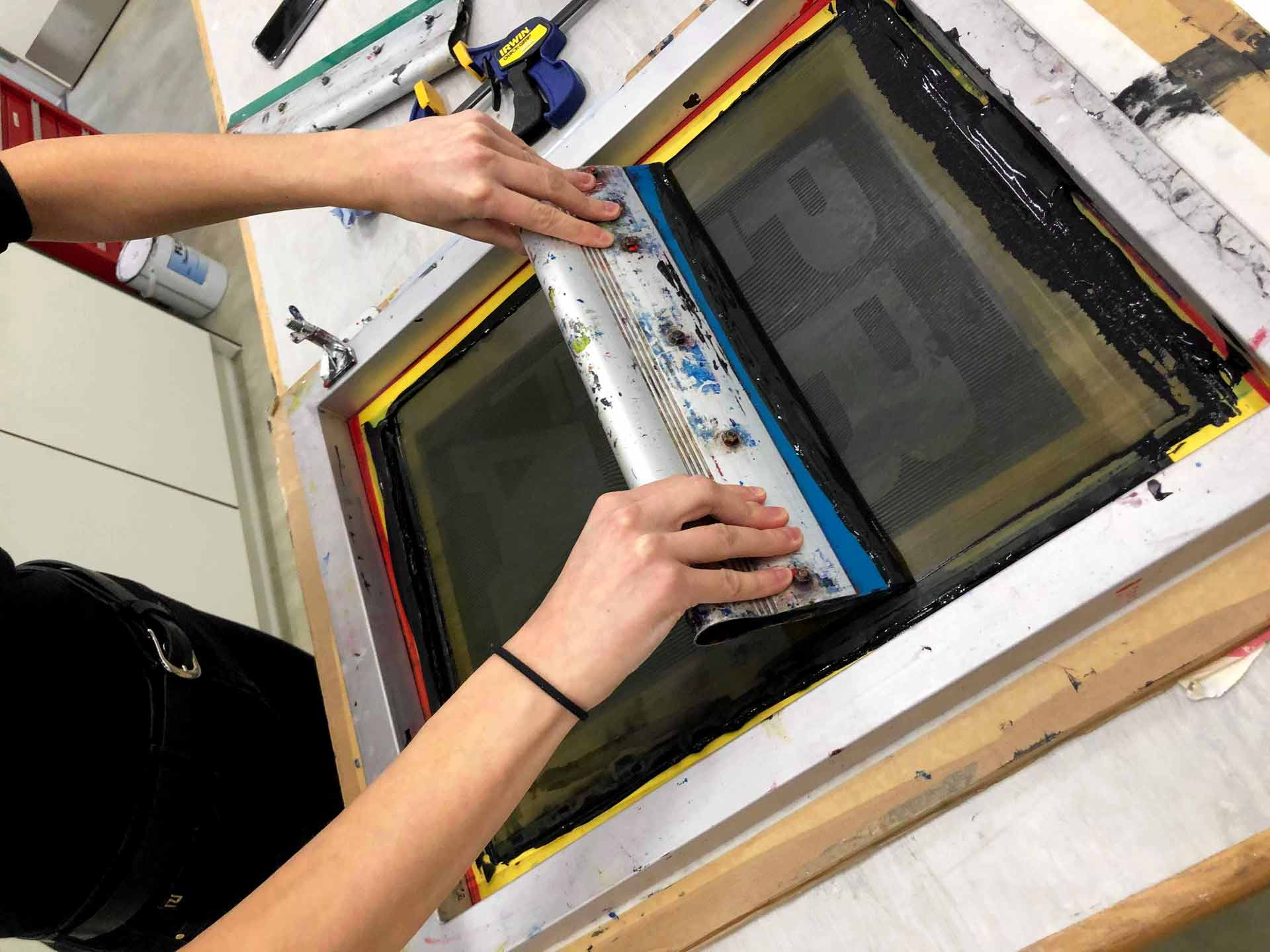 an image of someone screen printing