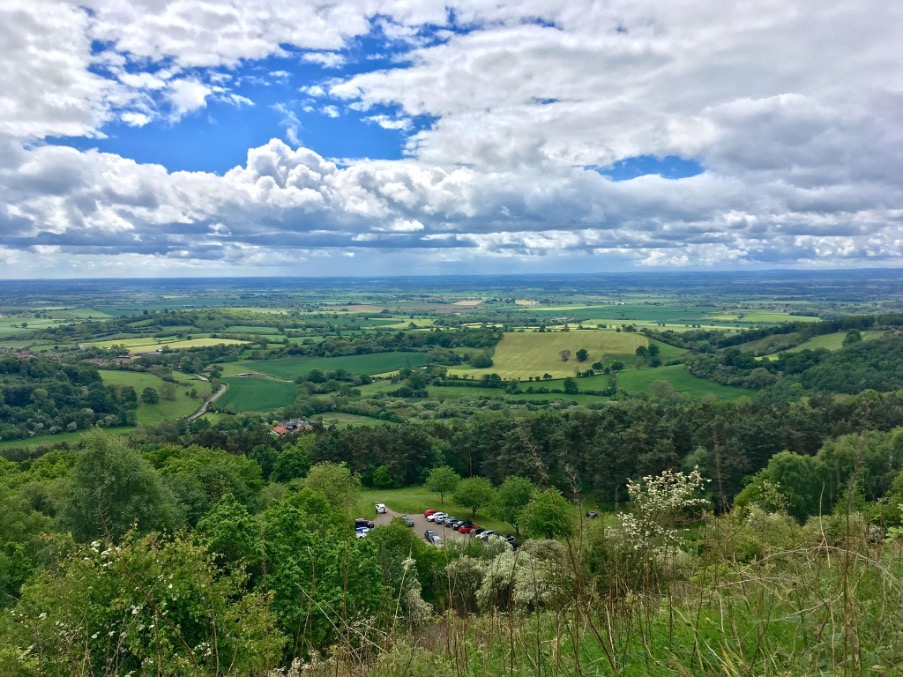 A view of Huddersfield featuring clouds and greenery